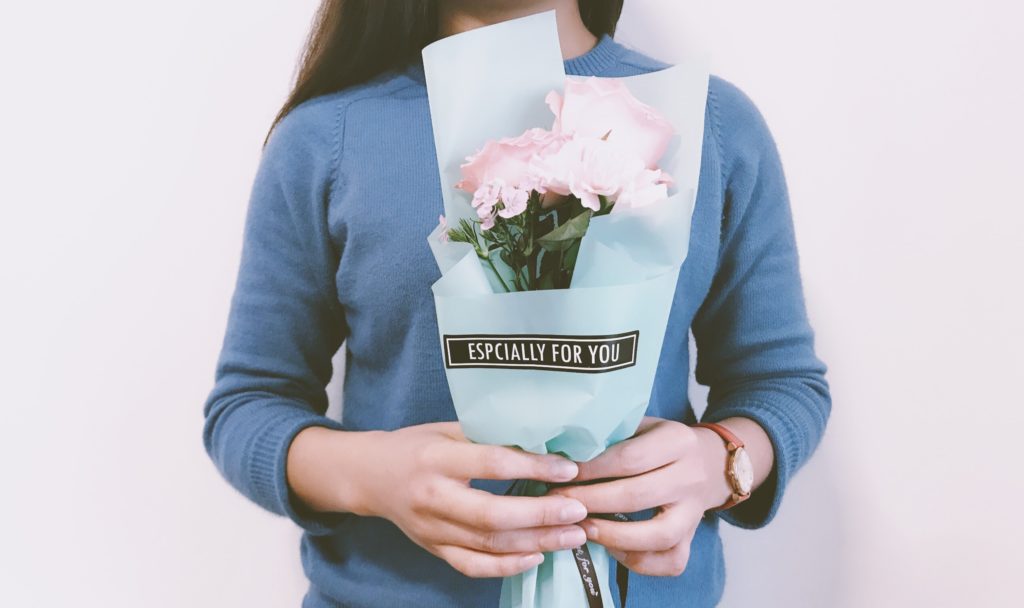 Woman receiving mother's day flowers that say especially for you.