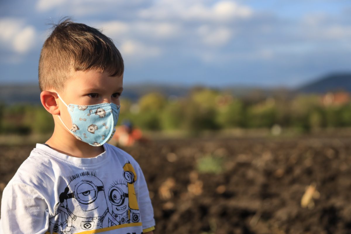 boy in field with mask on