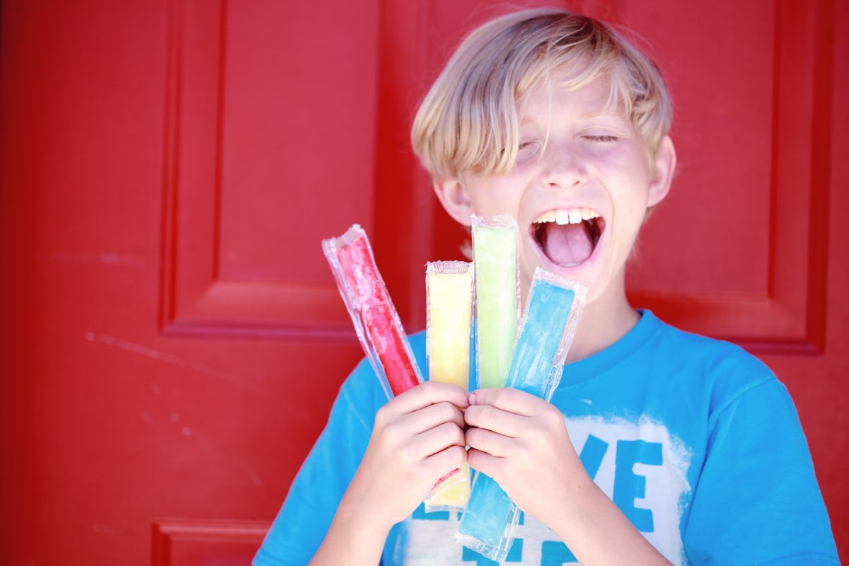 How To Tell If Your Kids Are Lying To You, Alison Escalante MD. A boy smiles widely as he holds up four popsicles