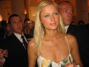 Photo of a young Paris Hilton flanked by bodyguards. 