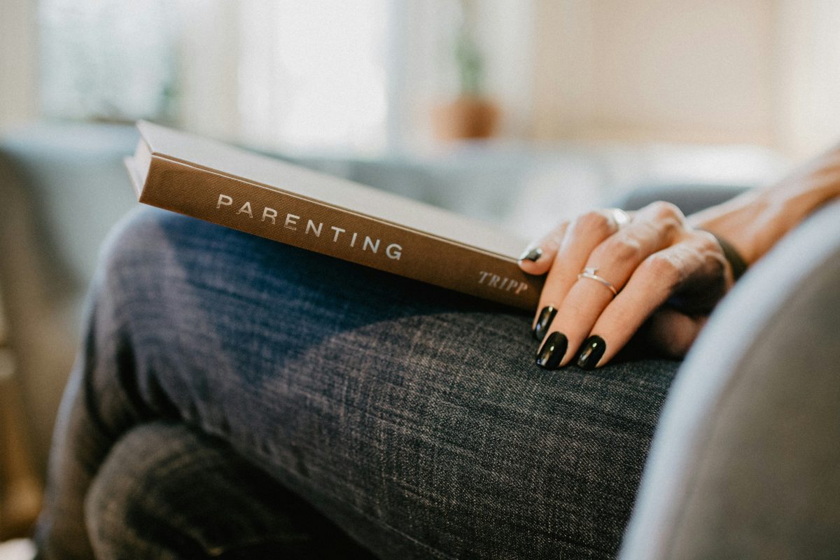 Woman holding book with title "Parenting"